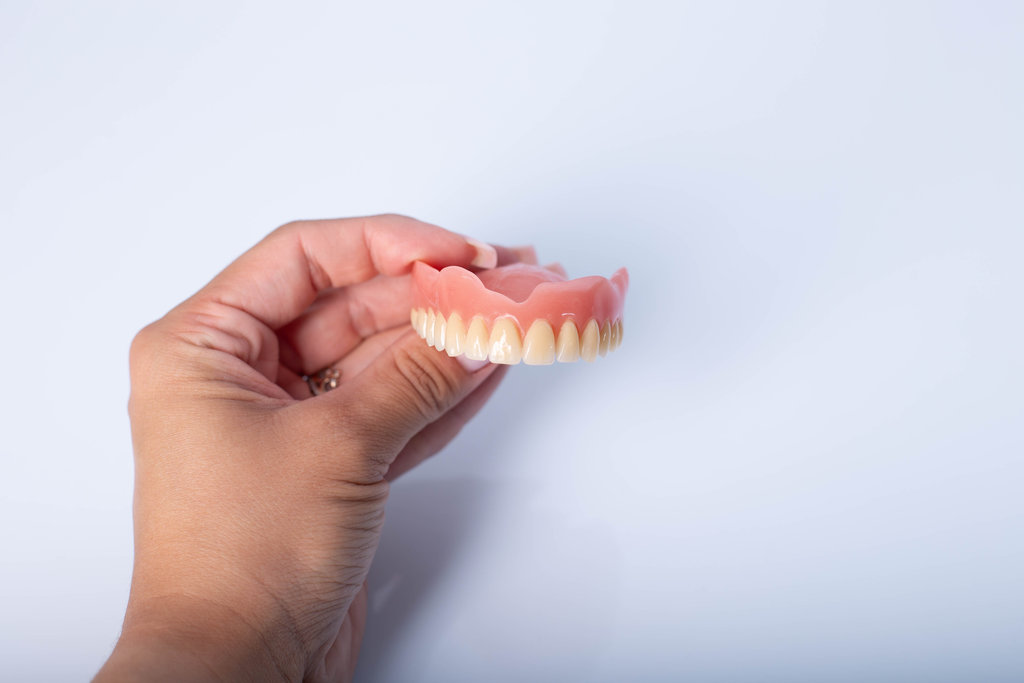 render of mandibular prosthesis all on 4 system supported by implants over white background